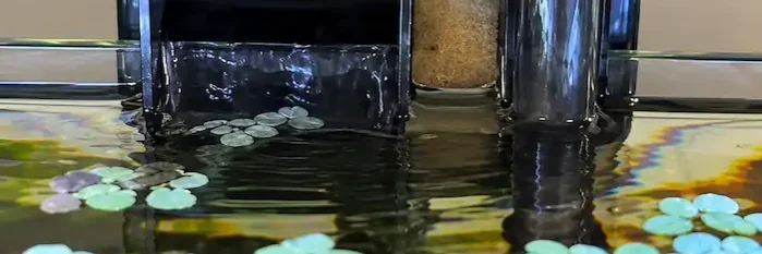 Low-flow aquarium filter installed in a planted betta fish tank with floating plants, gentle water movement, and visible sponge filtration media.